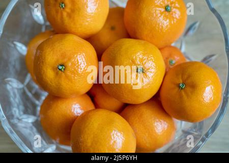 Frische Mandarinenorangen, auch bekannt als Citrus reticulata, in einem Kristallbogen platziert, köstliche Zitrusfrüchte, die als gesunder, nahrhafter Snack zu den Diäten hinzugefügt wurden Stockfoto