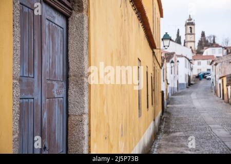 Alte Haustür mit der Kirche von Almeida im Hintergrund Stockfoto
