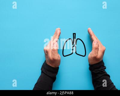 Männliche Hände schützen das Lungensymbol. Gesundheits- und Versicherungskonzept. Stockfoto