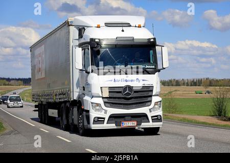 Weißer Mercedes-Benz Actros-Lkw zieht an einem sonnigen Frühlingstag den Freja-Sattelauflieger im Highway 10-Verkehr. Koski TL, Finnland. 14.Mai 2021. Stockfoto