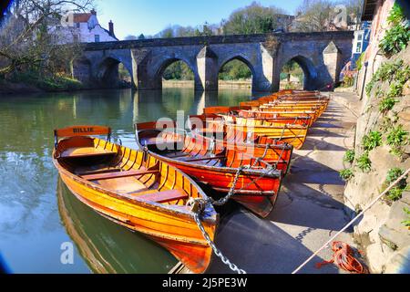 Ruderboote liegen am Flussufer mit der Elvet Bridge im Hintergrund. Durham City, County Durham, England, Großbritannien. Stockfoto