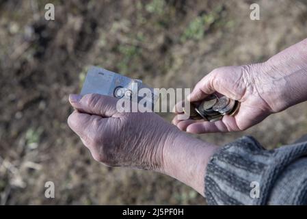 Eine Frau zählt kleines Geld in ihren Händen. Stockfoto