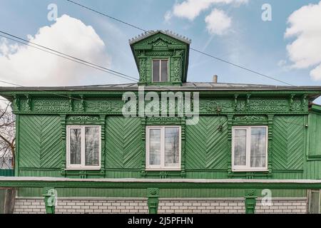 Fassade eines typischen russischen Landhauses mit Dachfenstern und geschnitzten Holzdekorationen Stockfoto