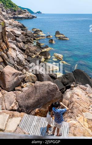 Vertikale Ansicht eines jungen Paares, das an einem schönen sonnigen Tag die Küste und die Felsen in der Bucht von Koh Tao beobachtet Stockfoto