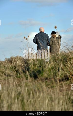 Älteres Paar, das auf einem grasbewachsenen Feld zusammensteht Stockfoto