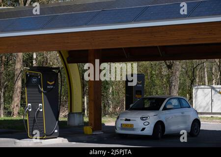 Elektrotransport. Laden eines Fiat 500E mit Strom an einer öffentlichen Ladestation im schnell wachsenden Kfz-Ladeletz von Fastned in den Niederlanden Stockfoto