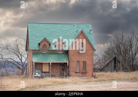 Ein altes, verlassene, gruselig aussehendes Bauernhaus im Winter auf einem Bauernhof im ländlichen Kanada Stockfoto