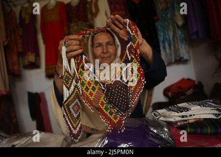 Bamiyan, Afghanistan. 19. März 2022. Eine afghanische Frau zeigt Kunsthandwerk auf einem Kunsthandwerksmarkt in Bamiyan, Zentralafghanistan, 19. März 2022. UM MIT "Feature: US-Sanktionen ziehen afghanische Frauen zurück in die Armut" zu GEHEN Kredit: Saifurahman Safi/Xinhua/Alamy Live News Stockfoto