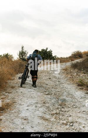 Professioneller Abfahrtsradarfahrer auf dem Bergweg Stockfoto