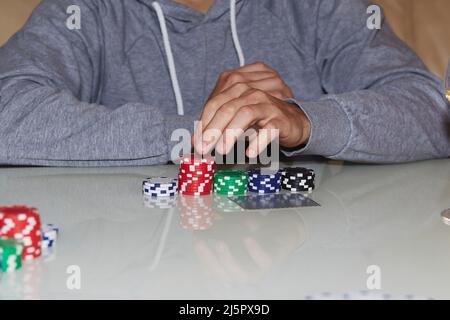 Pokerspiel: Chips, Karten auf dem Tisch. Spieler am Tisch. Genießen Sie den Moment, digitale Entgiftung mit Freunden. Selektiver Fokus Stockfoto