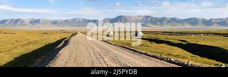 Unbefestigte Straße und Jurten in der Nähe von Son-Kul See und Tien shan Gebirge in Kirgisistan Stockfoto