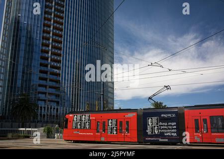 Rote Straßenbahn vor einem modernen Wolkenkratzer in der Innenstadt von San Diego Stockfoto
