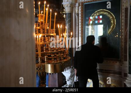 Während eines Gottesdienstes in Athen küsst der Mensch eine Ikone. Die Griechen feiern Ostern am Sonntag, dem 24. April, dem wichtigsten religiösen Feiertag im orthodoxen christlichen Kalender, zum ersten Mal seit zwei Jahren, ohne irgendwelche Einschränkungen im Zusammenhang mit dem Coronavirus für die Teilnahme an religiösen Gottesdiensten oder für die Anzahl der Personen, die sich versammeln können. Stockfoto