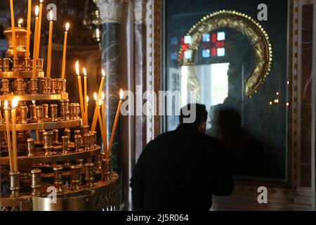 Während eines Gottesdienstes in Athen küsst der Mensch eine Ikone. Die Griechen feiern Ostern am Sonntag, dem 24. April, dem wichtigsten religiösen Feiertag im orthodoxen christlichen Kalender, zum ersten Mal seit zwei Jahren, ohne irgendwelche Einschränkungen im Zusammenhang mit dem Coronavirus für die Teilnahme an religiösen Gottesdiensten oder für die Anzahl der Personen, die sich versammeln können. Stockfoto