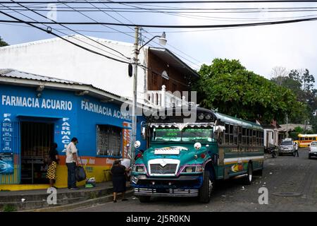 Juayua, El Salvador - 29. Januar 2022: Typischer Bus in El Salvador, genannt Hühnerbus in der Stadt Ruta de las Flores. Blick auf eine Straße mit lokalen Stockfoto