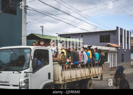 Juayua, El Salvador - 29. Januar 2022: In einer Stadt in Juayua in El Salvador wurden Menschen in einen Pick-up-Truck gepackt. Sitzt auf dem Rand eines fahrenden Autos Stockfoto