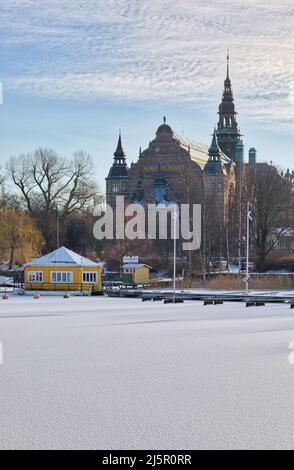 Blick über gefrorene Ladugardslandsviken zum Nordiska Museet (Nordisches Museum) auf der Insel Djurgarden, Stockholm, Schweden Stockfoto