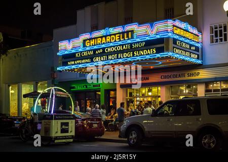 Nachtaufnahme des beleuchteten Ghirardelli-Schokoladenladens façade in der Gaslamp Quarter 5. Ave, San Diego Downtown Stockfoto