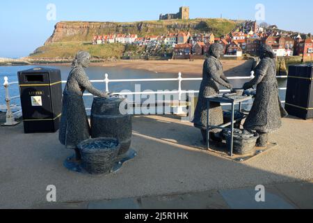 Die Herring Girls Skulptur von Emma Stothard mit Blick über den Hafen zur St. Mary's Kirche in Whitby North Yorkshire England Stockfoto