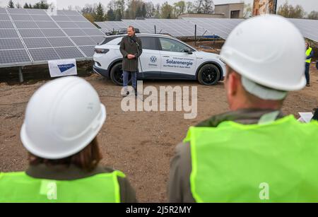 25. April 2022, Sachsen, Zwickau: Wolfram Günther (die Grünen), Sachsens Minister für Energie und Klimaschutz, spricht bei der Übergabe eines neuen Solarparks neben einem VW ID.4. Die Enerparc AG betreibt den sechs Hektar großen Solarpark Mosel und wird in den nächsten 20 Jahren jährlich 5,5 Millionen kWh Solarenergie für die Produktion der vollelektrischen Volkswagen-Modelle aus Zwickau liefern. Alle drei Volkswagen-Standorte in Sachsen werden bereits seit Ende 2017 mit Ökostrom aus Wasserkraft versorgt. Bisher kam dies jedoch aus Österreich. Zwickau ist nun der erste sächsische Standort, der neu ist Stockfoto