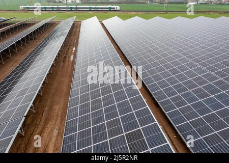 25. April 2022, Sachsen, Zwickau: Blick auf einen neuen Solarpark auf dem Gelände eines ehemaligen Marktgartens in Sichtweite des VW-Werks. Die Enerparc AG betreibt den sechs Hektar großen Solarpark Mosel und wird in den nächsten 20 Jahren jährlich 5,5 Millionen kWh Solarenergie für die Produktion der vollelektrischen Volkswagen-Modelle aus Zwickau liefern. Alle drei Volkswagen-Standorte in Sachsen werden bereits seit Ende 2017 mit Ökostrom aus Wasserkraft versorgt. Bisher kam dies jedoch aus Österreich. Zwickau ist nun der erste sächsische Standort, der Solarenergie für die Fahrzeugproduktion erhält. (Aeria Stockfoto