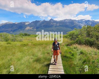 Neuseeland, Südinsel, Glenorchy-Gegend - Touristen gehen über eine Holzbrettwanderung, die die Feuchtgebiete schützt. Stockfoto