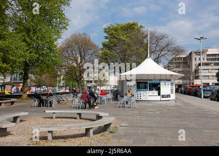 Plymouth, Devon, Großbritannien. 25.. April 2022. Ein sonniger Frühlingstag im Zentrum von Plymouth. Die Kunden genießen das wärmere, sonnige Wetter und genießen einen Kaffee aus dem Gel Stockfoto