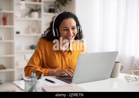 Glückliche Brünette Geschäftsfrau Mit Laptop Tragen Kopfhörer Arbeiten Am Arbeitsplatz Stockfoto