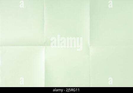 Hellgrüner, zerknitterter, ungefalzter Papierbogen-Texturhintergrund. Papier in sechs gefaltet. Vollformat Stockfoto