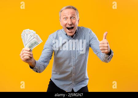 Aufgeregt reifen Mann hält Geld Bargeld zeigen wie Stockfoto