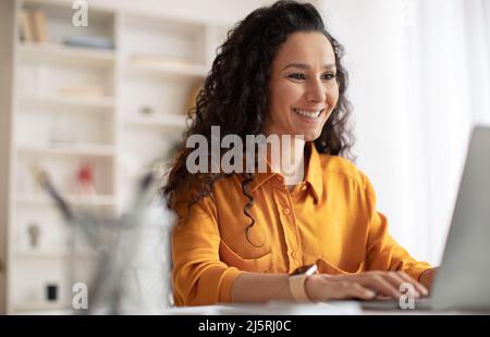 Fröhliche Brünette Geschäftsfrau Mit Laptop Arbeiten Im Modernen Büro Stockfoto