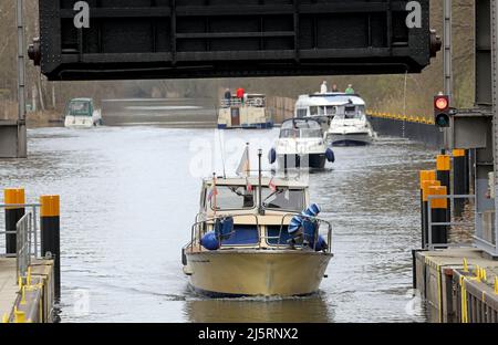 Mirow, Deutschland. 21. April 2022. Boote fahren auf der Müritz-Havel-Wasserstraße in die Schleuse. Der Wassertourismus auf der Mecklenburgischen Seenplatte steht kurz vor dem Beginn einer neuen Saison. Quelle: Bernd Wüstneck/dpa/Alamy Live News Stockfoto