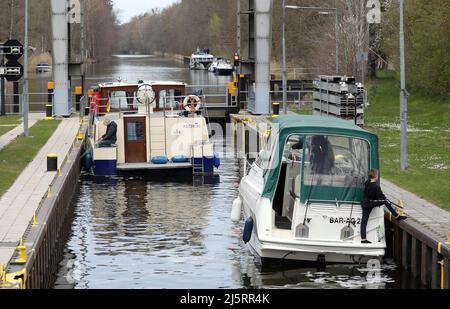 Mirow, Deutschland. 21. April 2022. Boote verlassen die Schleuse auf der Müritz-Havel-Wasserstraße. Der Wassertourismus auf der Mecklenburgischen Seenplatte steht kurz vor dem Beginn einer neuen Saison. Quelle: Bernd Wüstneck/dpa/Alamy Live News Stockfoto