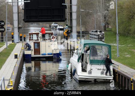 Mirow, Deutschland. 21. April 2022. Boote verlassen die Schleuse auf der Müritz-Havel-Wasserstraße. Der Wassertourismus auf der Mecklenburgischen Seenplatte steht kurz vor dem Beginn einer neuen Saison. Quelle: Bernd Wüstneck/dpa/Alamy Live News Stockfoto