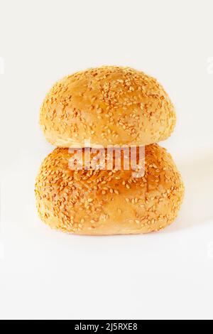 Ein appetitliches Brötchen, bestreut mit Sesamsamen auf weißem Hintergrund. Köstliche leichte Snacks. Isoliert Stockfoto