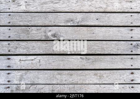 Graue Holzplanken Hintergrund Textur. Echte Holzbretter horizontal mit rostigen Schrauben. Altertes Material mit verwitterter Struktur. Abstrakter Hintergrund Stockfoto