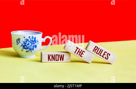 Kennen Sie die Regeln Wort auf Holzblöcke isoliert auf einem roten und gelben Hintergrund. Business-Prozess-Regulierung Konzept. Stockfoto