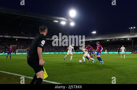 Der Linienmann beobachtet, wie Jack Harrison von Leeds United während des Premier League-Spiels im Selhurst Park, London, mit Jordan Ayew von Crystal Palace kämpft. Bilddatum: Montag, 25. April 2022. Stockfoto