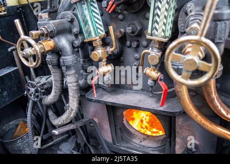 Feuer in der Feuerstelle einer Hunslet Sparity 0-6-0 Satteltank-Dampfmaschine, die walisische trockene Dampfkohle verbrennt. Bedienelemente in der Kabine Stockfoto