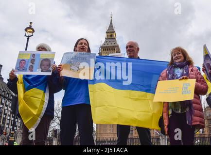 London, Großbritannien. 25. April 2022. Demonstranten halten während der Demonstration ukrainische Fahnen und Plakate zur Unterstützung der Flüchtlinge. Auf dem Parliament Square versammelten sich Häuser für die Ukraine, um gegen die Visumverzögerungen für Flüchtlinge aus der Ukraine zu protestieren. Die Gastgeber fordern, dass die Regierung den Visumsantrag beschleunigt und vereinfacht. Kredit: SOPA Images Limited/Alamy Live Nachrichten Stockfoto