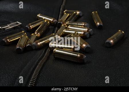 .44 Magnum Revolvermunition auf schwarzem Lederhintergrund (Biker-Jacke) Stockfoto