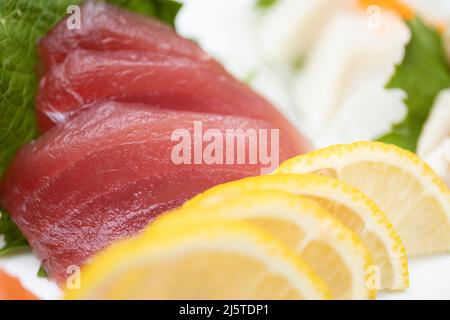 Frisches Sushi auf einem Teller mit Zitronen und Blumen Stockfoto