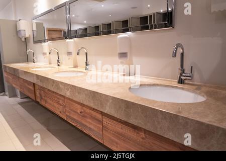 Eine Reihe von Waschbecken in der Sportdusche und in der Umkleidekabine Stockfoto