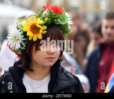 Krakau, Polen. 24. April 2021. Während der Demonstration wird eine junge Frau mit einer Blumenkrone und ukrainischen und polnischen Fahnen auf ihrem Gesicht gesehen. In Krakau fand ein solidaritätsmarsch mit der Ukraine statt. (Foto von Alex Bona/SOPA Images/Sipa USA) Quelle: SIPA USA/Alamy Live News Stockfoto