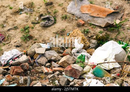 Unschärfe riesige Ruinen, Wrack in der Ukraine, Krieg. Haus nach dem russischen Angriff. Große Müllhaufen auf Natur grünen Gras Hintergrund, globale Erwärmung. Verschmutzung. Stockfoto