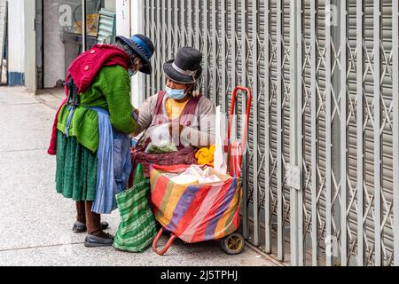 Eine indigene Frau verkauft Käse und Coca-Blätter in der Straße, Puno, Provinz Puno, Peru. Stockfoto