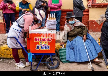 Eine Frau, die Eiscreme in der Straße, Puno, Provinz Puno, Peru verkauft. Stockfoto