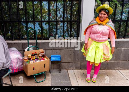 Eine junge Frau in traditionellem Kostüm, die Honig auf den Straßen von Puno, Provinz Puno, Peru verkauft. Stockfoto