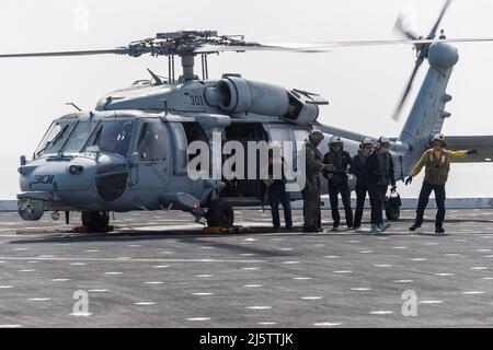 220409-N-VQ947-1045 PAZIFISCHER OZEAN (9. April 2022) – Ehrengäste des „Leaders to Sea“-Programms kommen an Bord der Amphibienstation USS Portland (LPD 27) mit einem Hubschrauber der SH-60 Sea Hawk, 9. April 2022. Portland führt derzeit Routineoperationen in der US 3.-Flotte durch. (USA Navy Foto von Mass Communication Specialist 2. Class Devin Kates) Stockfoto