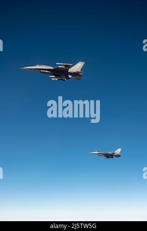 Zwei F-16 kämpfende Falcons fliegen in Formation, nachdem sie Treibstoff von einem KC-135 Stratotanker vom Luftwaffenstützpunkt Fairchild über New Mexico erhalten haben, 14. April 2022. Crews aus Fairchild unterstützten während einer Trainingsmission die Flugzeugbetankung, so dass die F-16-Crews ihre Einsatzbereitschaft aufrechterhalten konnten. (USA Luftwaffe Foto von Staff Sgt. Ryan Gomez) Stockfoto